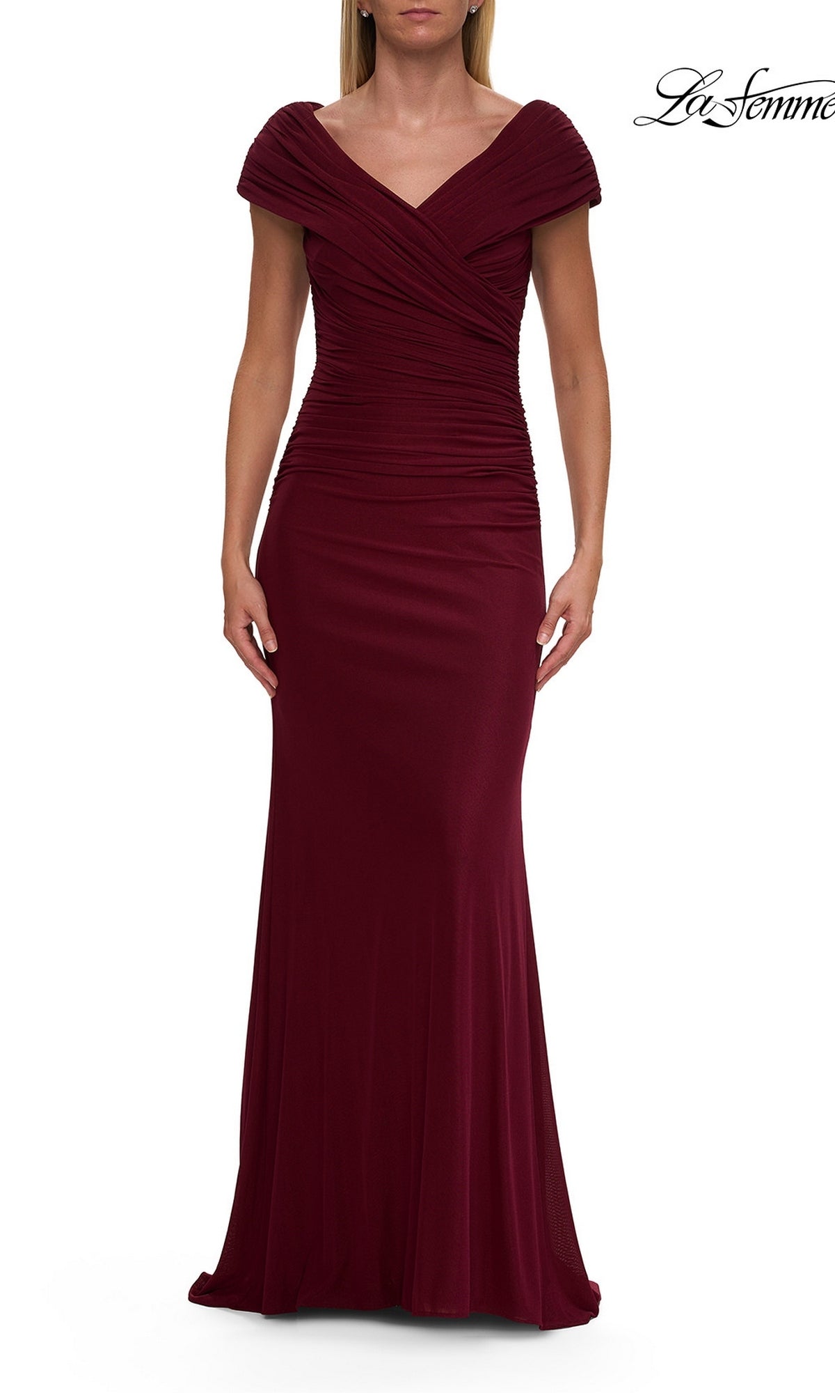 A woman wearing a floor-length, cap-sleeve La Femme 29558 long formal dress in dark berry with ruched detailing and a fitted silhouette against a white background.